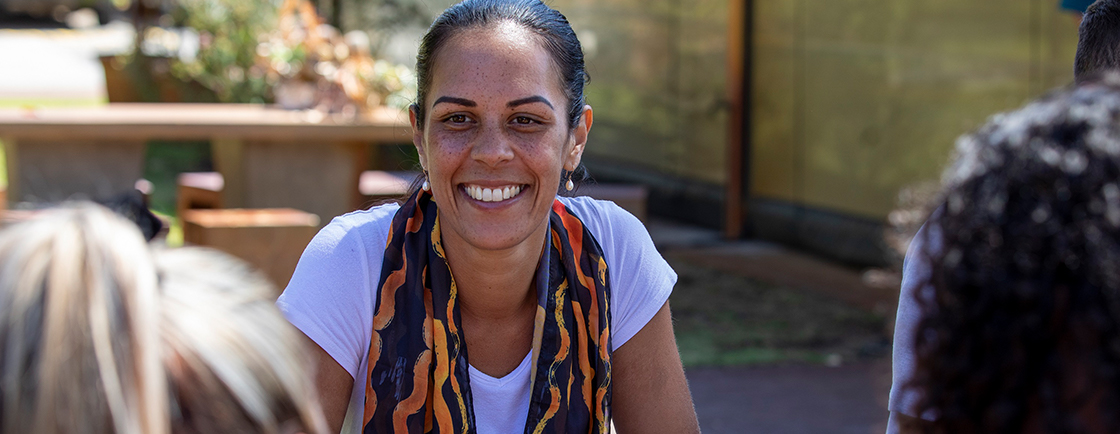 Smiling young woman facing camera, sitting outside