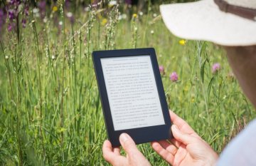 Man reading kindle outdoors